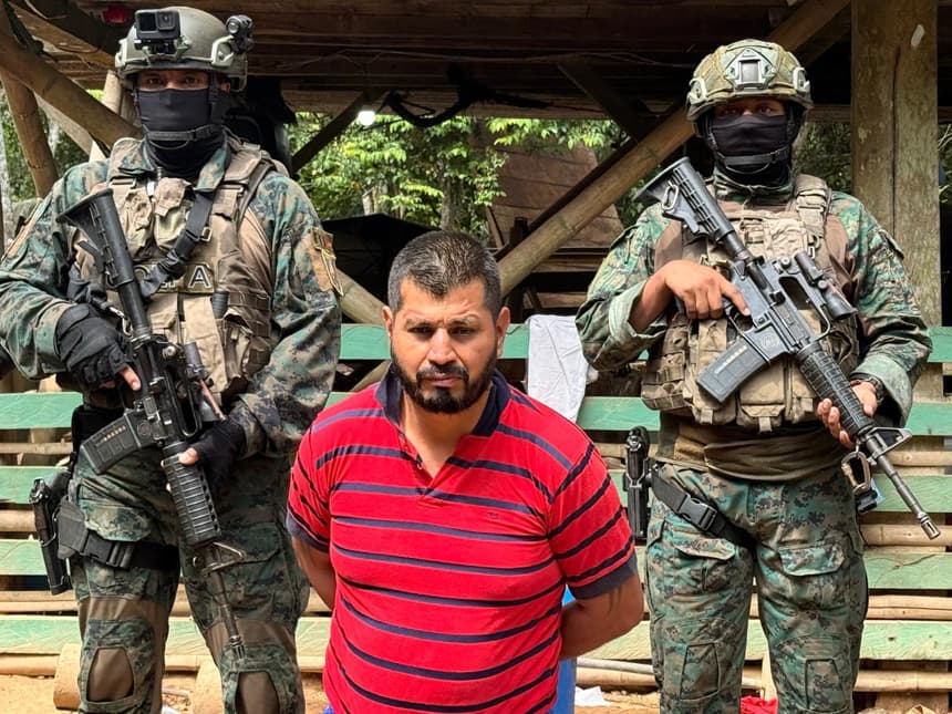 Fotografía cedida por el Ministerio de Defensa de Ecuador que muestra a Rubén Dario Álava (c) alias 'Camarada' custodiado por militares. (EFE/ Ministerio de Defensa de Ecuador)