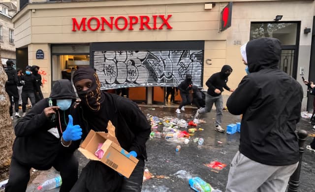 Manifestantes enmascarados saquean un supermercado Monoprix en el bulevar Saint-Denis de París durante las violentas manifestaciones del 17 de octubre de 2026. (Etienne Fauchaire/The Epoch Times)