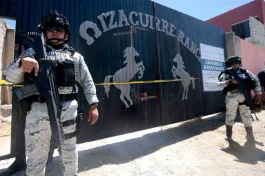 Oficiales de la Guardia Nacional vigilan la visita de miembros del colectivo "Guerreros Buscadores" al rancho Izaguirre, donde el 5 de marzo localizaron tres hornos crematorios humanos durante la búsqueda de sus familiares desaparecidos en la comunidad de La Estanzuela, Teuchitlán, Jalisco, México, el 13 de marzo de 2025. (ULISES RUIZ/AFP vía Getty Images)