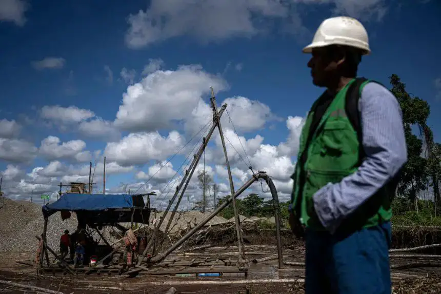 Un minero frente a una draga en una zona de extracción de oro en el departamento de Madre de Dios, en la Amazonía peruana, el 31 de mayo de 2024. (Ernesto BENAVIDES/AFP vía Getty Images)