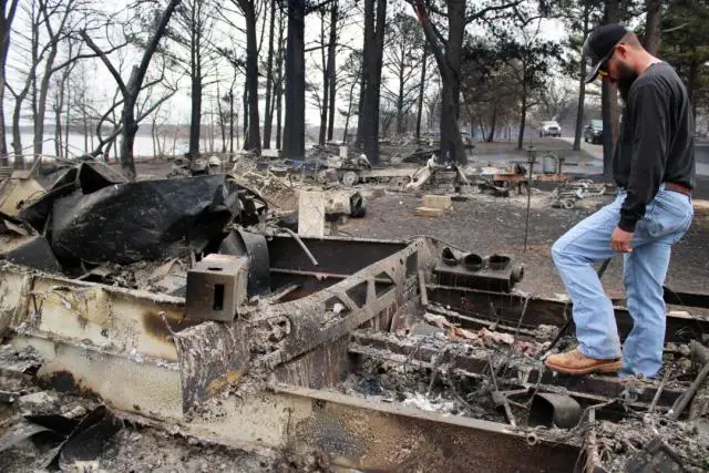 Dacota Roberson examina los restos calcinados de la caravana de sus padres en el lago Carl Blackwell, a las afueras de Stillwater, Oklahoma, el 15 de marzo de 2025. (Michael Clements/The Epoch Times)