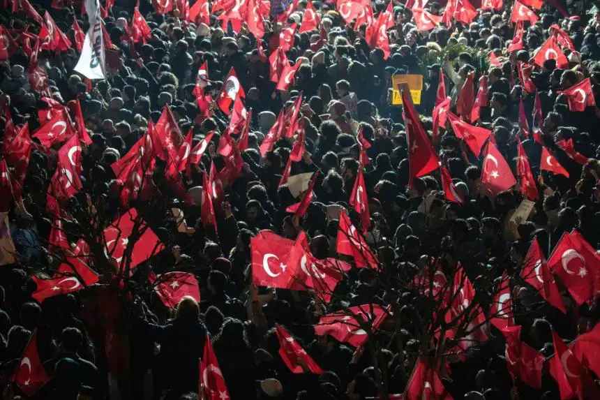 La gente ondea banderas y corea consignas durante una protesta frente a la sede del municipio en apoyo del alcalde de Estambul arrestado, Ekrem Imamoglu, el 19 de marzo de 2025 en Estambul, Turquía. (Chris McGrath/Getty Images)