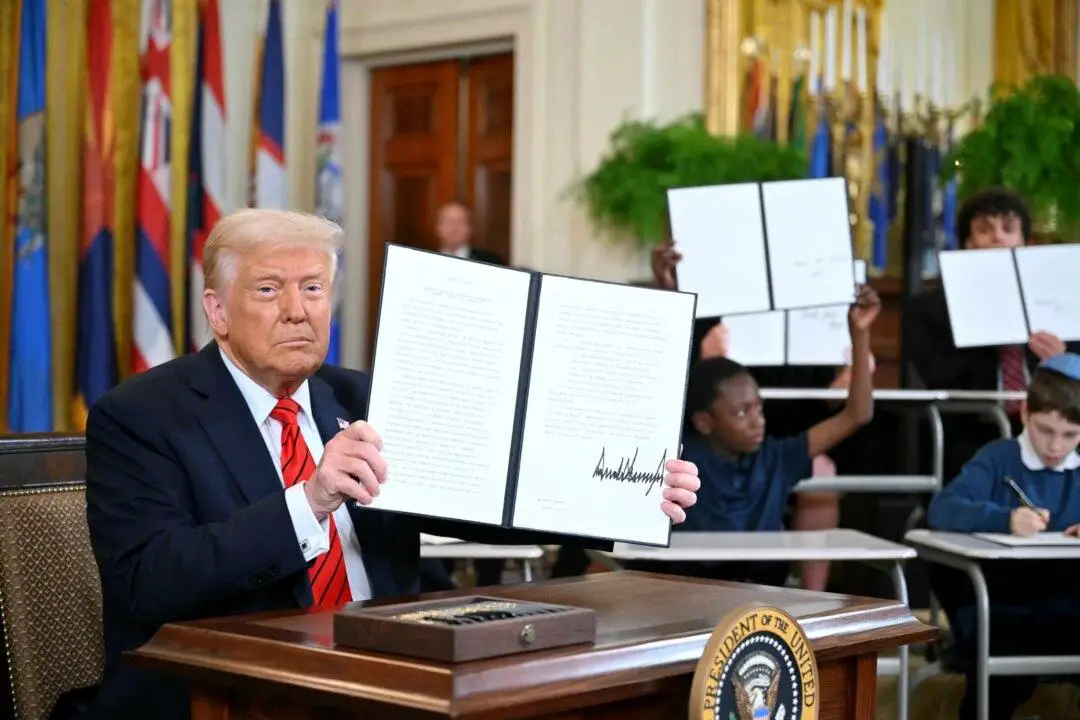 El presidente Donald Trump sostiene una orden ejecutiva que desmantela el Departamento de Educación de Estados Unidos, en Washington, el 20 de marzo de 2025. (Mandel Ngan/AFP vía Getty Images)