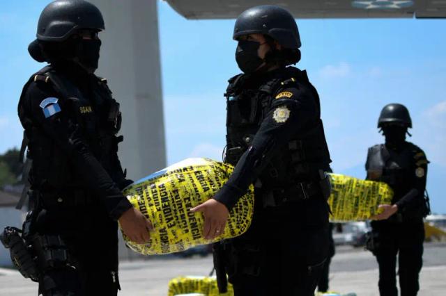 Agentes de la policía portaban paquetes con cocaína incautada a su llegada a la base aérea de la Ciudad de Guatemala (Guatemala), el 4 de abril de 2022. (Johan Ordonez/AFP vía Getty Images)