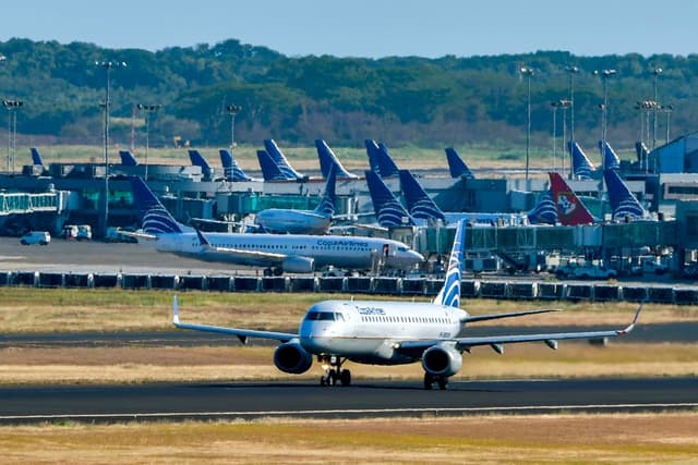 Un avión de Copa Airlines avanza por una pista mientras otros permanecen sentados en la misma en el Aeropuerto Internacional de Tocumen, Panamá, el 22 de marzo de 2020. (Luis Acosta/AFP vía Getty Images)