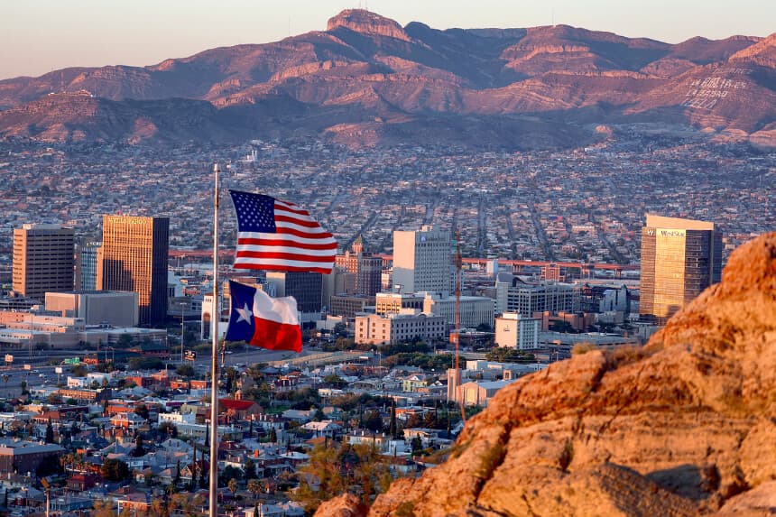 Una bandera estadounidense y otra de Texas ondean frente al horizonte de El Paso y Ciudad Juárez en El Paso, Texas, el 23 de septiembre de 2022. (Joe Raedle/Getty Images).