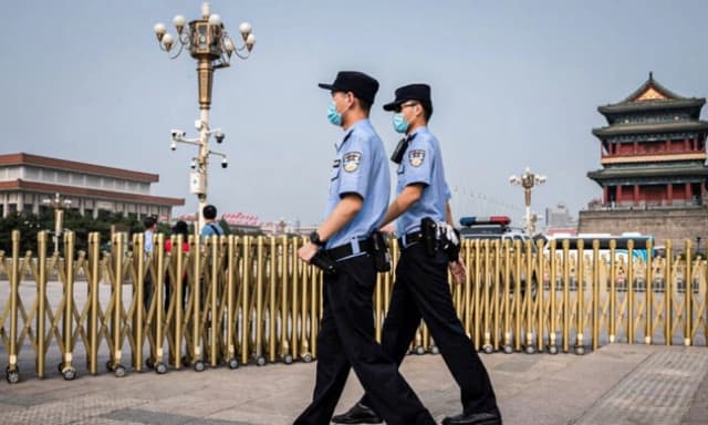 Agentes de policía patrullan una zona a las afueras de la plaza de Tiananmén de Beijing durante el Día Mundial de la Libertad de Prensa, el 3 de mayo de 2020. (Nicolas Asfouri/AFP vía Getty Images)
