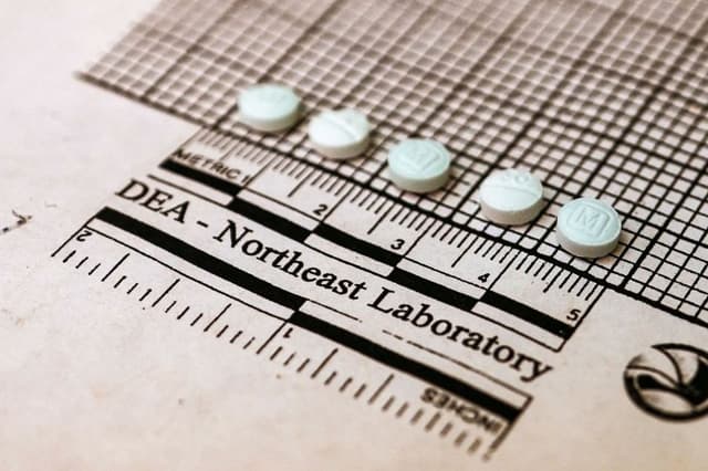 Tabletas sospechosas de contener fentanilo se colocan en un gráfico para medir su tamaño en el Laboratorio Regional del Noreste de la DEA en Nueva York el 8 de octubre de 2019. (Don Emmert/AFP vía Getty Images)