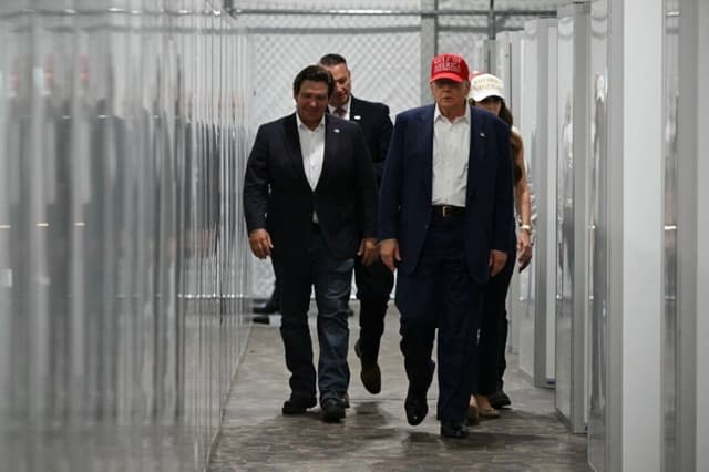 El gobernador de Florida, Ron DeSantis (izquierda), el presidente Donald Trump (centro) y la secretaria de Seguridad Nacional, Kristi Noem (derecha), visitan un centro médico durante una visita a un centro de detención de inmigrantes ilegales, apodado "Alligator Alcatraz", situado en el aeropuerto de entrenamiento y transición Dade-Collier, en Ochopee, Florida, el 1 de julio de 2025. (Andrew Caballero-Reynolds / AFP)