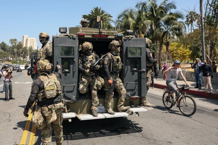 Agentes de Aduanas y Protección Fronteriza viajan en un vehículo blindado que avanza lentamente por Wilshire Boulevard, cerca del Parque MacArthur en Los Ángeles, el 7 de julio de 2025. (Patrick T. Fallon/AFP vía Getty Images)
