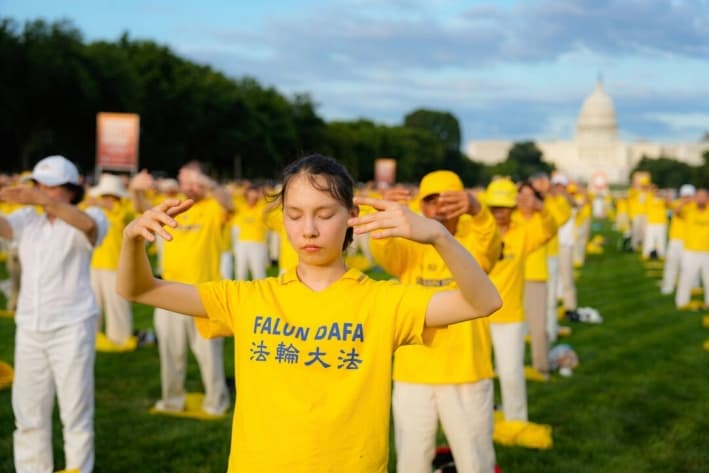 Practicantes de Falun Gong durante un evento para conmemorar a los asesinados por el régimen comunista chino, en el National Mall de Washington, el 11 de julio de 2024. (Larry Dye/The Epoch Times)