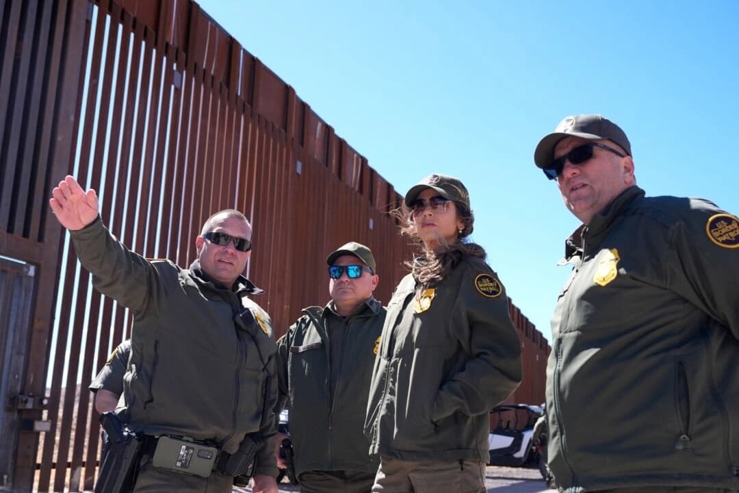 La secretaria de Seguridad Nacional, Kristi Noem (2.ª por la derecha), escucha durante una visita a lo largo del muro fronterizo en el puerto de entrada de Mariposa, en Nogales (Arizona), el 15 de marzo de 2025. (Alex Brandon/Pool/AFP a través de Getty Images)