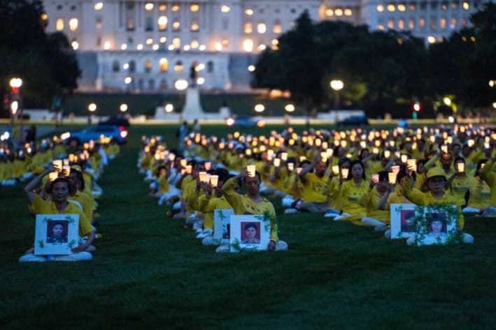 Los practicantes de Falun Dafa participan en una vigilia con velas en conmemoración de los practicantes de Falun Gong que fueron perseguidos hasta la muerte por el Partido Comunista Chino, en Washington, el 17 de julio de 2025. (Madalina Kilroy/The Epoch Times)