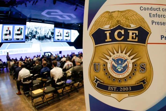 La gente espera mientras se muestran videos mientras el Servicio de Inmigración y Control de Aduanas de Estados Unidos (ICE) realiza un importante evento de contratación, en Arlington, Texas, el 26 de agosto de 2025. (Ron Jenkins/Getty Images)