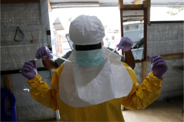 Un trabajador de la salud se pone el equipo de protección contra el ébola antes de ingresar a la Unidad de Atención de Emergencia Biosegura en el centro de tratamiento del ébola de la Alianza para la Acción Médica Internacional en Beni, en la República Democrática del Congo, el 31 de marzo de 2019. (REUTERS/Baz Ratner/Foto de archivo).
