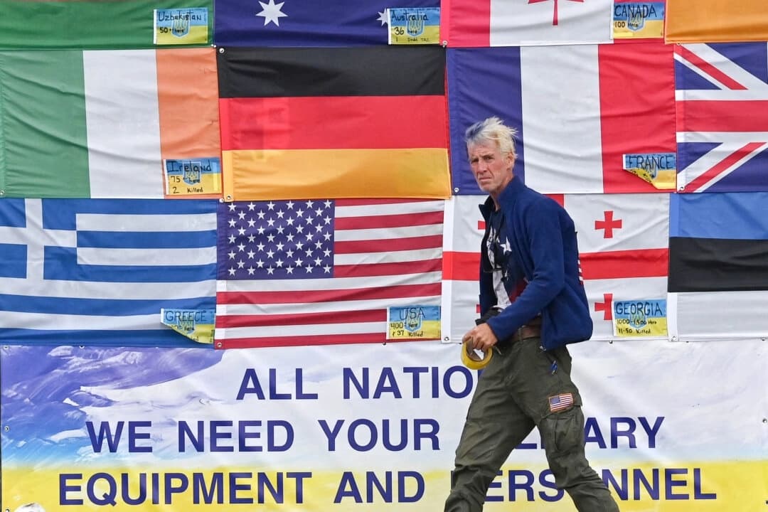El ciudadano estadounidense Ryan Wesley Routh cuelga banderas nacionales de países que ayudan a Ucrania en Kiev, Ucrania, el 23 de junio de 2022. (Sergei Supinsky/AFP a través de Getty Images)