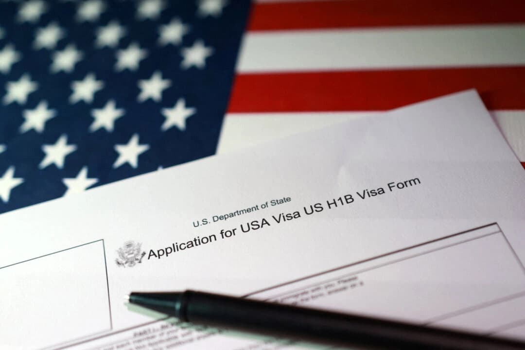 En esta ilustración, tomada el 22 de septiembre de 2025, se ven una bandera estadounidense y un formulario de solicitud de visa H-1B. (Dado Ruvic/Ilustración/Reuters)