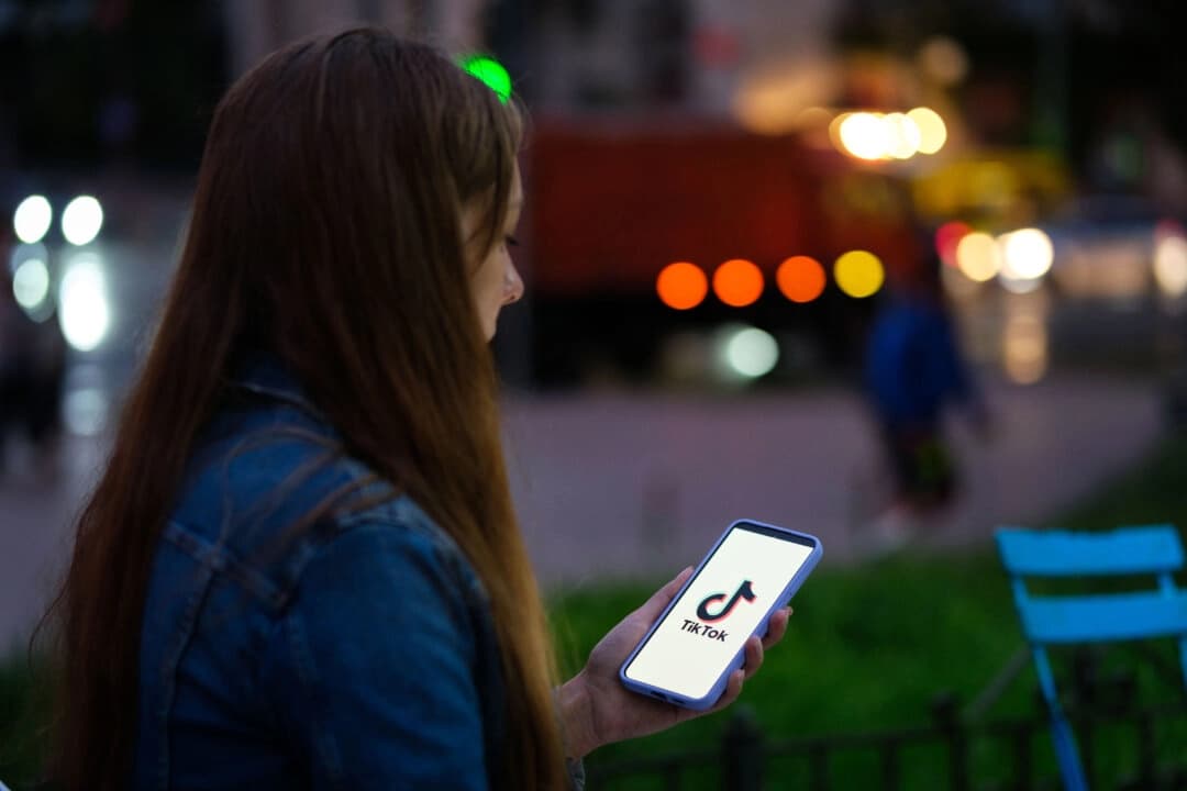 Una mujer sostiene un teléfono con la aplicación TikTok, en esta foto de archivo, el 11 de agosto de 2024. (Oleksii Pydsosonnii/The Epoch Times)