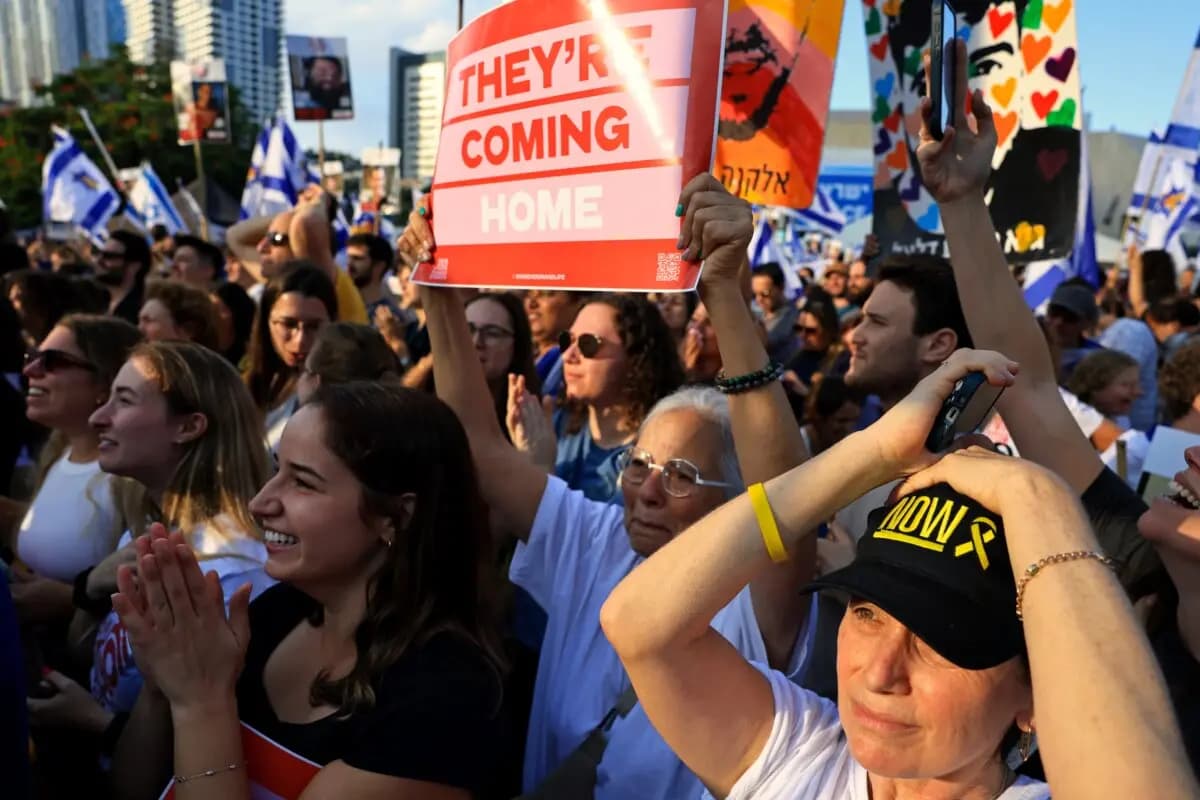 La gente reacciona mientras ve la retransmisión en directo de la liberación de los rehenes en la Plaza de los Rehenes de Tel Aviv, Israel, el 13 de octubre de 2025. (Chris McGrath/Getty Images)