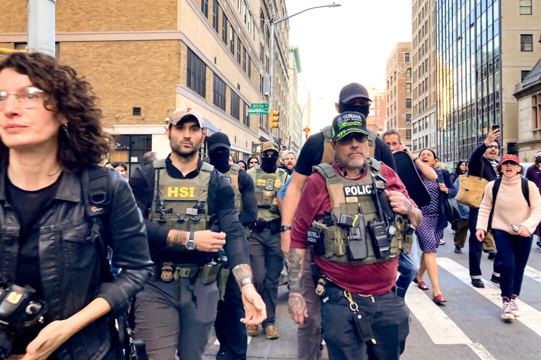 Agentes federales caminan por la calle Lafayette mientras los manifiestos los siguen después de un operativo de control de inmigración en Canal Street a través de Chinatown en la ciudad de Nueva York el 21 de octubre de 2025. (Jake Offenhartz/Foto AP)