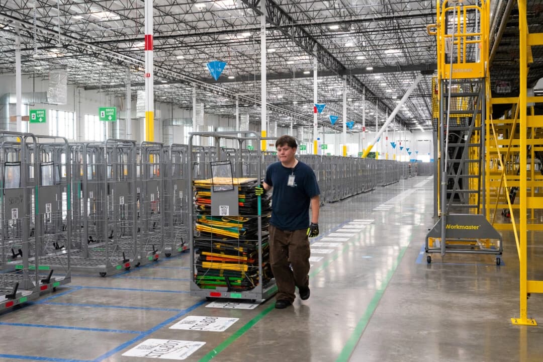 Un empleado lleva bolsas de clasificación en la estación de entrega DUR3 de Amazon en Milpitas, California, el 22 de octubre de 2025. (Laure Andrillon/AFP vía Getty Images)