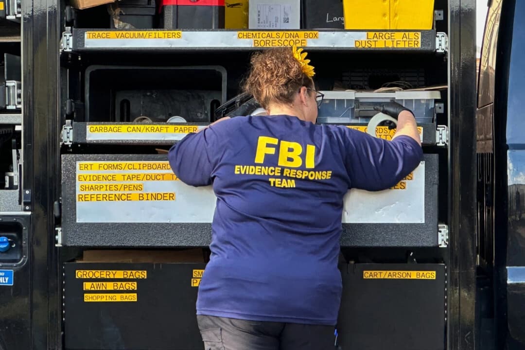 Un agente del FBI está junto a un camión del Equipo de Respuesta a la Evidencia afuera de una casa en un vecindario de Dearborn, Michigan, el 31 de octubre de 2025. (Foto de Mike Householder/AP)