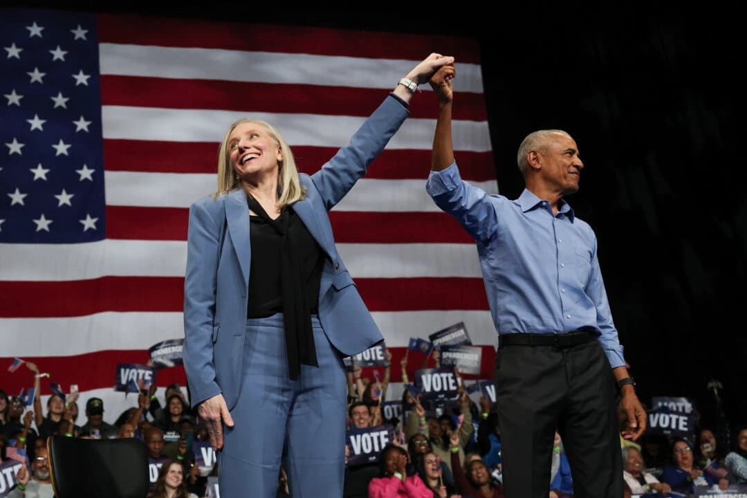 El expresidente de Estados Unidos Barack Obama (der.) y la candidata demócrata a la gobernatura de Virginia, la exrepresentante Abigail Spanberger (izq.), levantan los brazos juntos durante un mitin de campaña en el Chartway Arena de Norfolk, Virginia, el 1 de noviembre de 2025. (Win McNamee/Getty Images)