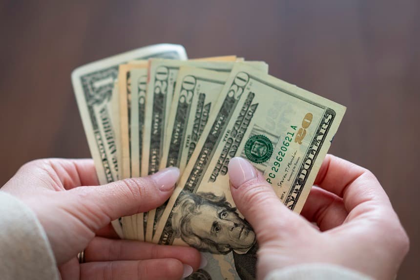 Una mujer cuenta billetes de dólar en Washington el 2 de mayo de 2024. (Joseph Lord/The Epoch Times)