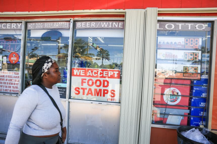 Una mujer pasa junto a un cartel que anuncia la aceptación de cupones de alimentos, en Miami, Florida, el 31 de octubre de 2025. (Joe Raedle/Getty Images).