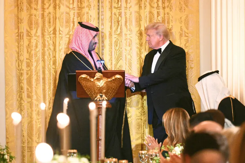 El presidente de los Estados Unidos, Donald Trump (derecha), estrecha la mano del príncipe heredero y primer ministro del Reino de Arabia Saudita, Mohammed bin Salman, durante una cena oficial en el Salón Este de la Casa Blanca en Washington, D.C., el 18 de noviembre de 2025. (Foto de BRENDAN SMIALOWSKI/AFP a través de Getty Images)
