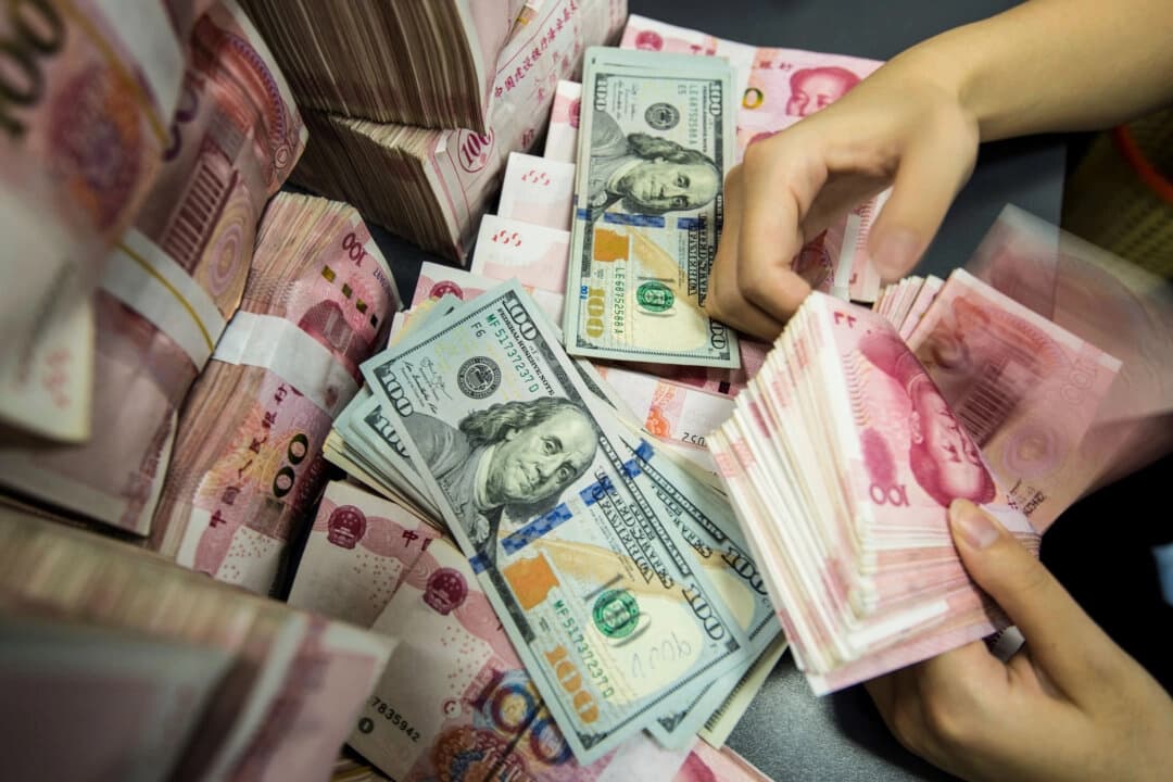 Un empleado bancario chino cuenta billetes de 100 yuanes y dólares estadounidenses en la ventanilla de un banco en Nantong, provincia de Jiangsu, al este de China, el 28 de agosto de 2019. (AFP vía Getty Images)