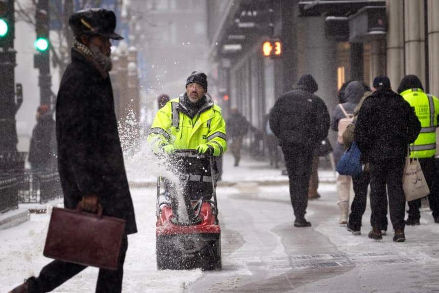 Un trabajador retira la nieve de una acera en el Loop mientras una tormenta invernal pasa sobre la ciudad el 12 de febrero de 2025 en Chicago, Illinois. (Scott Olson/Getty Images)