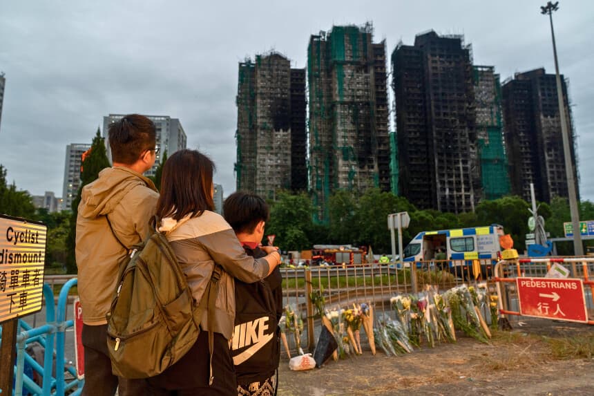 HONG KONG, CHINA - 30 DE NOVIEMBRE: Las personas depositan flores frente al Wang Fuk Court tras el mortal incendio ocurrido en el distrito Tai Po de Hong Kong el 30 de noviembre de 2025 en Hong Kong, China. Hong Kong observa tres días de luto oficial por las víctimas del fatal incendio en un edificio de apartamentos que se cobró 146 vidas. (Foto de Anthony Kwan/Getty Images).