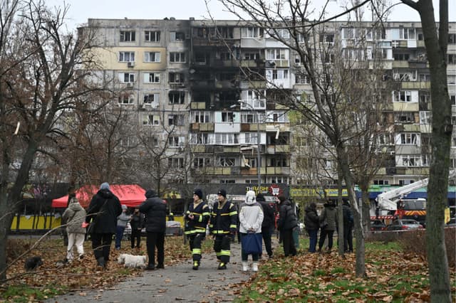 Policías y residentes locales en el patio de un edificio residencial dañado tras un ataque aéreo en Kiev, el 29 de noviembre de 2025. (Genya SAVILOV/AFP a través de Getty Images)