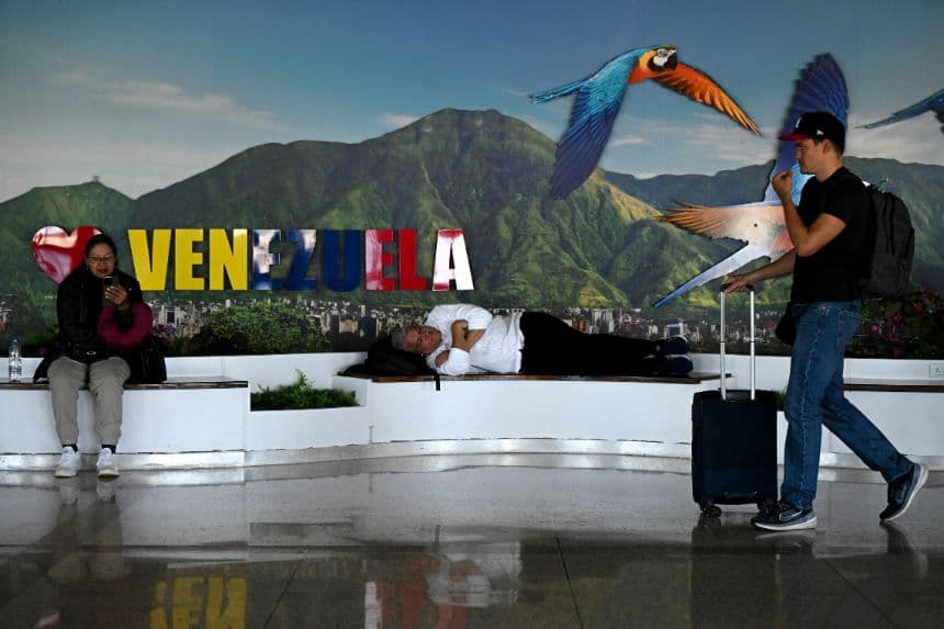 Personas descansan cerca de una puerta de embarque en el Aeropuerto Internacional Simón Bolívar de Maiquetía, estado de La Guaira, Venezuela, el 30 de noviembre de 2025. (Federico PARRA / AFP vía Getty Images)