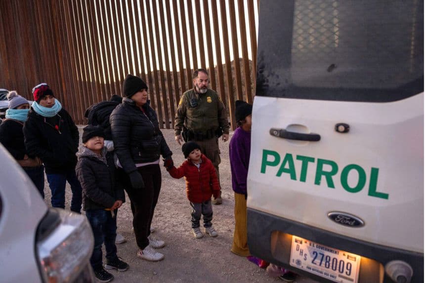 Agentes de la Patrulla Fronteriza de EE. UU. vigilan a los inmigrantes junto a la valla fronteriza entre EE. UU. y México antes de trasladarlos para su tramitación el 19 de enero de 2025 cerca de Sasabe, Arizona. (John Moore/Getty Images)