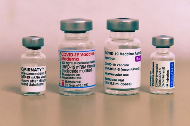 Viales vacíos de las vacunas contra el coronavirus de varios fabricantes (de izq a derecha) Comirnaty de Pfizer/BioNTech, Moderna, AstraZeneca y Janssen de Johnson & Johnson se ven sobre una mesa en un centro de vacunación en Sonthofen, sur de Alemania, el 30 de noviembre de 2021 (CHRISTOF STACHE/AFP vía Getty Images)