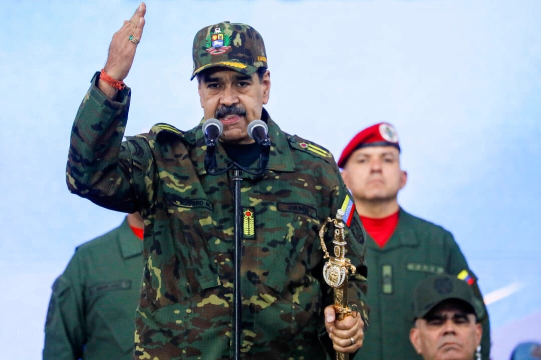 El líder venezolano, Nicolás Maduro, sostiene la espada de Simón Bolívar mientras se dirige a miembros de las fuerzas armadas, la Milicia Bolivariana, la policía y civiles durante una manifestación contra una posible escalada de las acciones estadounidenses hacia el país, en la base militar de Fuerte Tiuna en Caracas, Venezuela, el 25 de noviembre de 2025. (REUTERS/Leonardo Fernández Viloria)