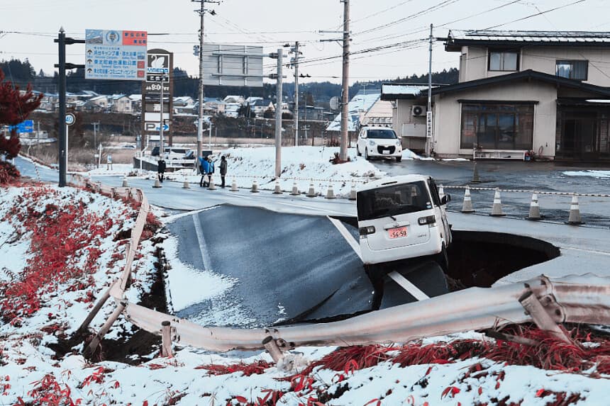 Un vehículo descansa al borde de una carretera derrumbada en la localidad de Tohoku, en la prefectura de Aomori, el 9 de diciembre de 2025, tras un terremoto de magnitud 7.5 frente a la costa norte de Japón. Un gran terremoto frente a la costa norte de Japón dejó al menos 30 heridos, según informaron las autoridades el 9 de diciembre, dañando carreteras y dejando a miles de personas sin electricidad en temperaturas bajo cero. (JIJI Press / AFP a través de Getty Images) / Japón OUT