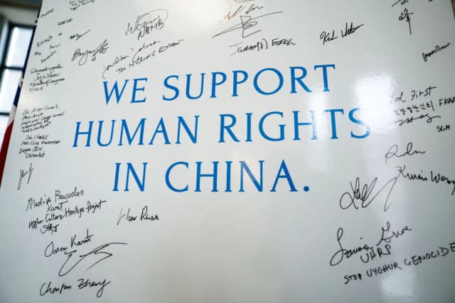 Las personas firman un cartel en apoyo a los derechos humanos en China durante la Feria de Defensa de los Derechos Humanos en China, celebrada en el edificio Rayburn House Office Building, en Capitol Hill, Washington, el 10 de diciembre de 2025. (Madalina Kilroy/The Epoch Times).