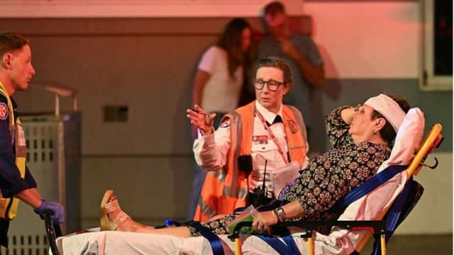 Los servicios de emergencia trasladan a una mujer en camilla a una ambulancia tras un tiroteo en Bondi Beach, Sídney, el 14 de diciembre de 2025. (Saeed KHAN / AFP a través de Getty Images)