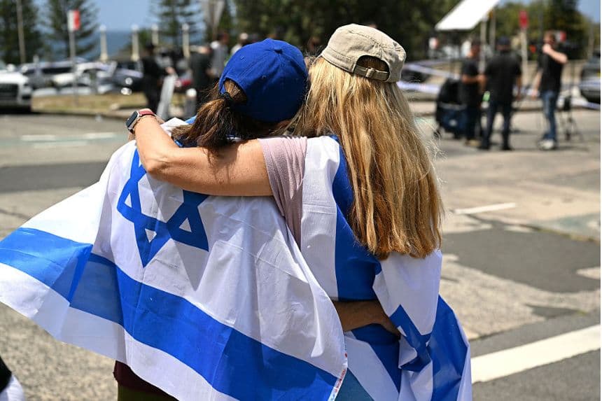 Miembros de la comunidad judía local se abrazan en el Bondi Pavillion en memoria de las víctimas de un tiroteo en Bondi Beach, en Sídney, el 15 de diciembre de 2025. (Saeed KHAN / AFP vía Getty Images)