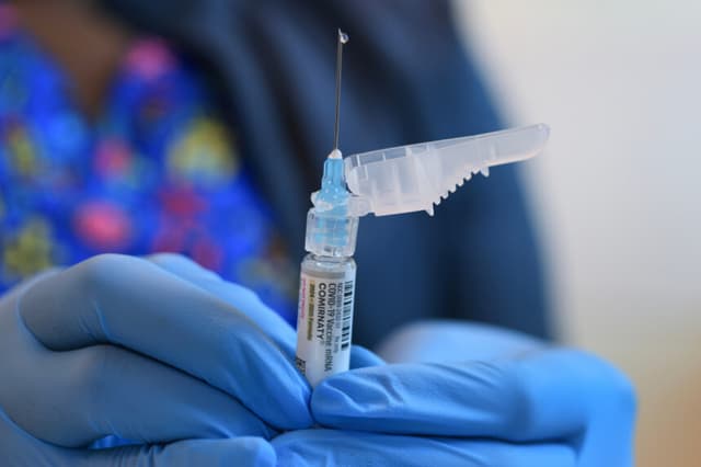 Ruth Jones, enfermera especializada en inmunización, sostiene una vacuna contra la COVID-19 de Pfizer-BioNTech en el Centro de Salud Borinquen, en Miami, Florida, el 29 de mayo de 2025. (Joe Raedle/Getty Images)