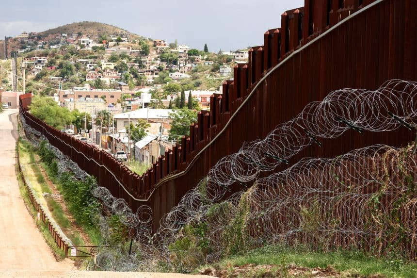 Rollos de alambre de púas bordean el muro fronterizo entre Estados Unidos y México en Nogales, Arizona, el 17 de septiembre de 2025. (CHARLY TRIBALLEAU/AFP a través de Getty Images)