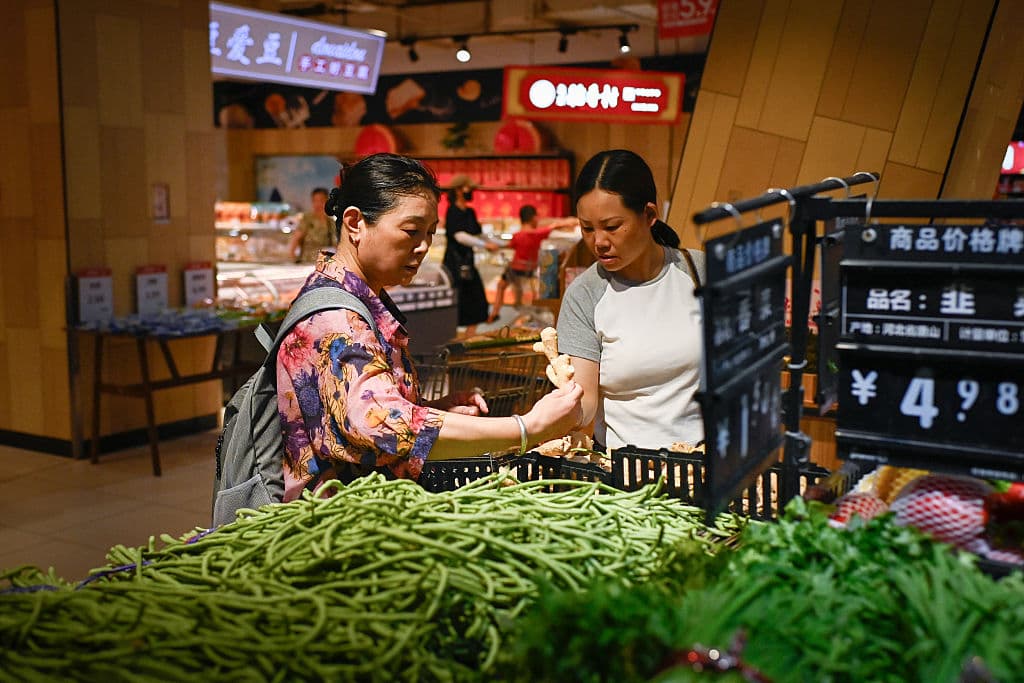 Personas seleccionando verduras en un supermercado de Beijing el 9 de julio de 2025. (Foto de WANG Zhao / AFP) (Foto de WANG ZHAO/AFP a través de Getty Images)