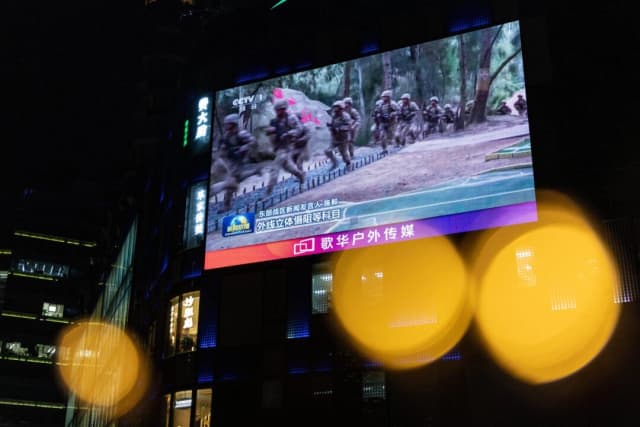 Una pantalla gigante transmite noticias sobre las maniobras militares de China alrededor de Taiwán a través de decoraciones navideñas, en Pekín, el 29 de diciembre de 2025. Maxim Shemetov/Reuters