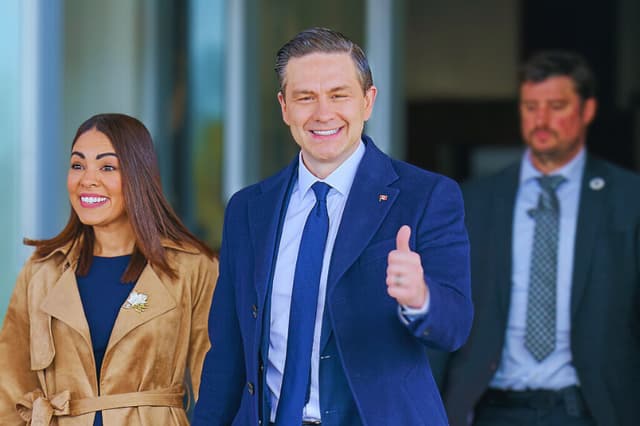 El líder conservador Pierre Poilievre levanta el pulgar mientras él y su esposa, Anaida, salen de un centro de votación después de votar en Ottawa, Ontario, Canadá, el 28 de abril de 2025. (GEOFF ROBINS/AFP a través de Getty Images)