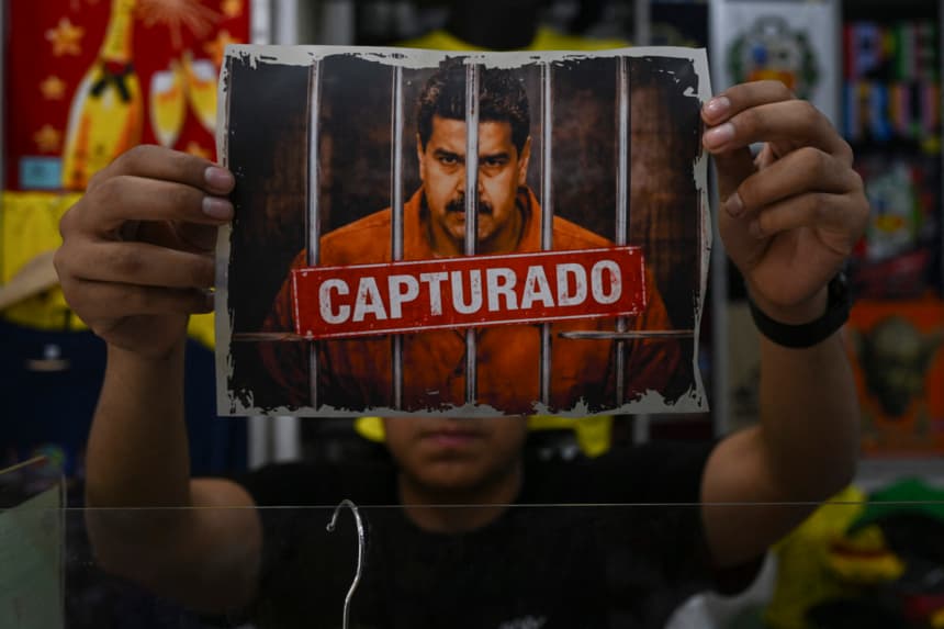 Un hombre muestra una imagen que presenta una versión alterada digitalmente del depuesto presidente venezolano Nicolás Maduro antes de imprimirla en una camiseta para su venta en el «Emporio Comercial de Gamarra» en Lima, el 6 de enero de 2026. (ERNESTO BENAVIDES / AFP via Getty Images)