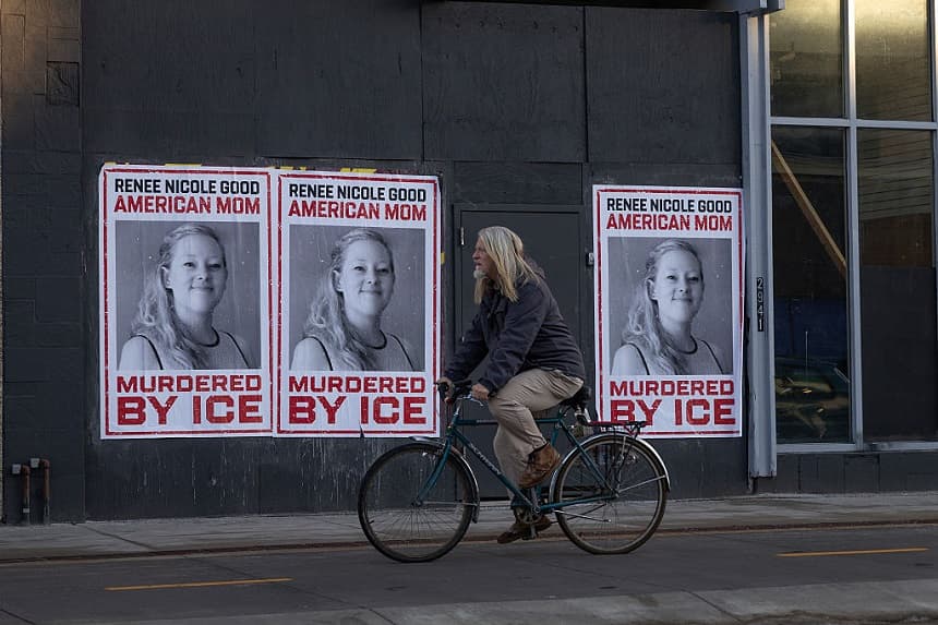 Un ciclista pasa junto a carteles de Renee Good el 12 de enero de 2026 en Minneapolis, Minnesota. (Scott Olson/Getty Images)