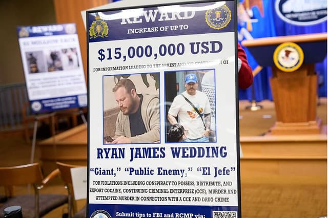Se puede ver un cartel con la recompensa por la detención de Ryan James Wedding tras una rueda de prensa en la que se anunció la acusación formal del ex snowboarder olímpico Ryan Wedding, acusado de asesinato y lavado de dinero en relación con una organización de tráfico de drogas, en el Departamento de Justicia, el 19 de noviembre de 2025, en Washington, D. C. (Andrew Harnik/Getty Images)